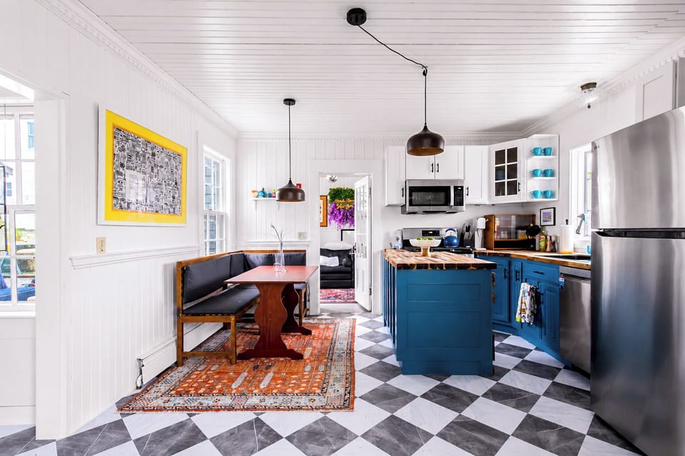 Bright designer kitchen with blue cabinets, island, and cozy breakfast nook