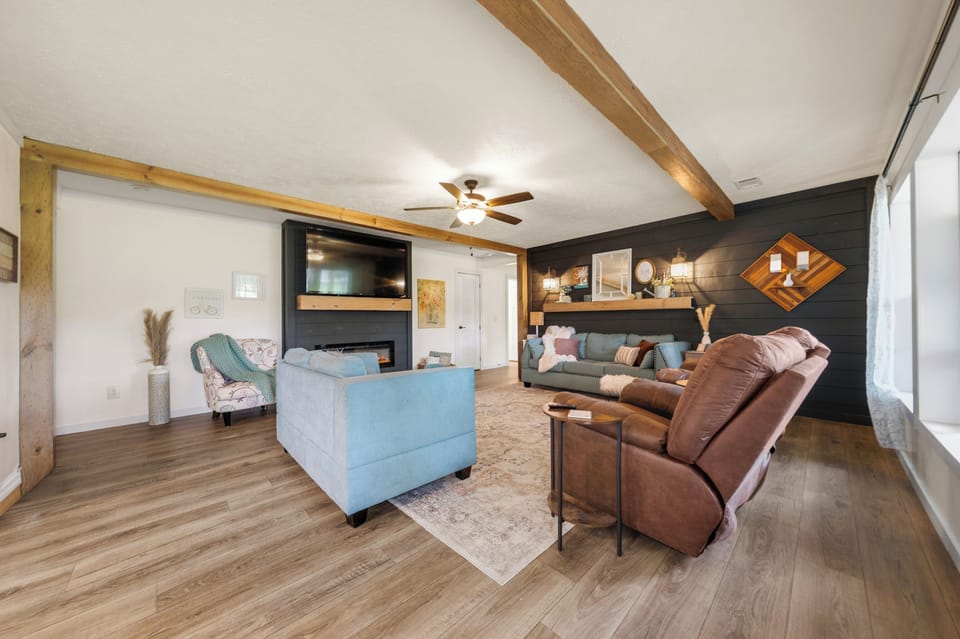 Spacious cozy living room with fireplace, TV, and stylish modern touches