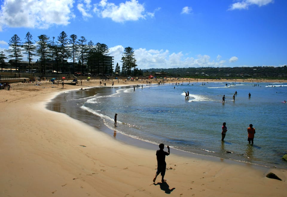 Wide sandy beach with calm waters and a scenic, family-friendly shoreline