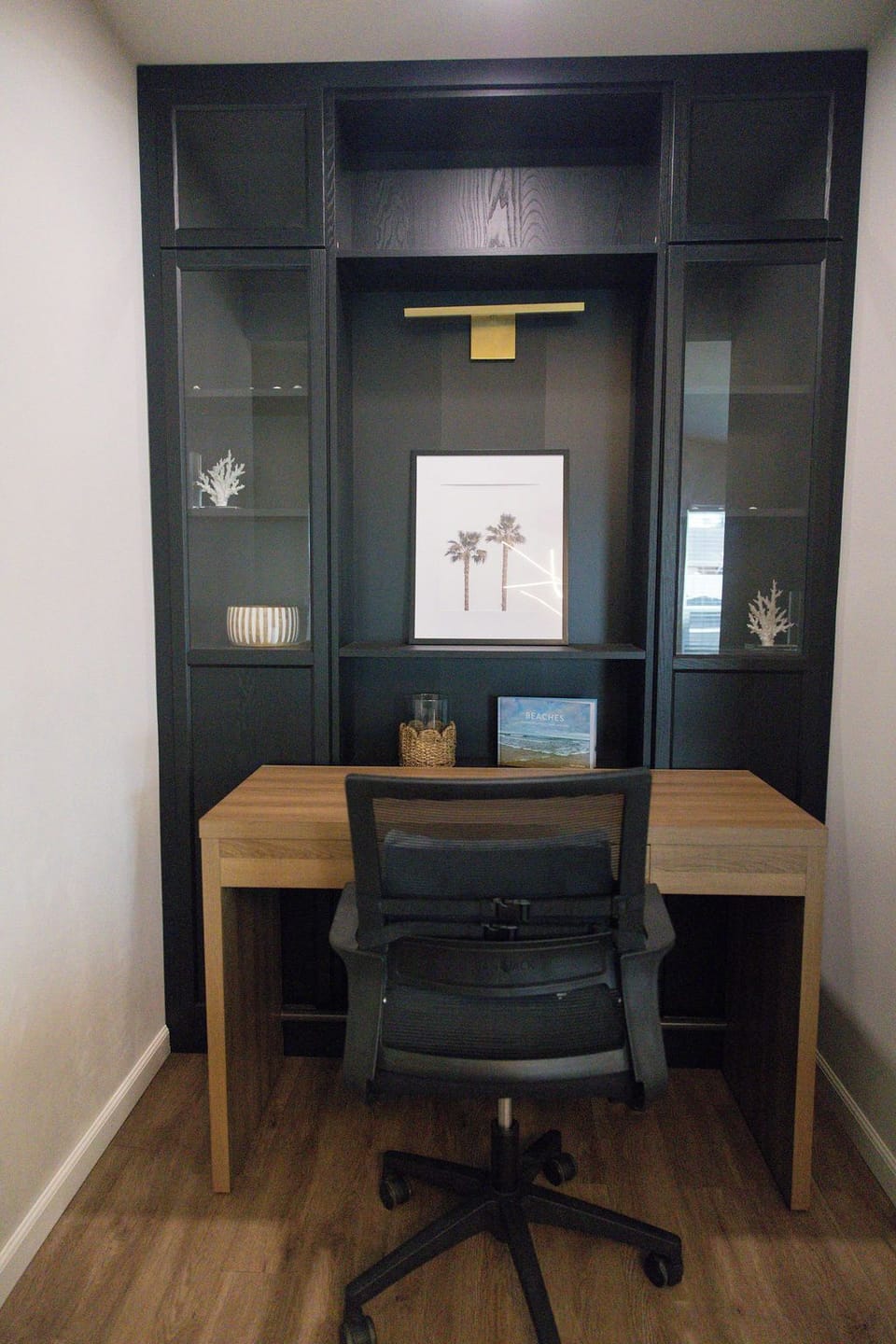 Stylish built-in workspace with desk, display shelves, and office chair