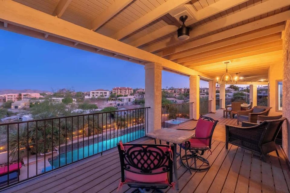 Unwind on your covered terrace overlooking the shimmering pool below. Warm desert hues frame evening skies, while comfortable seating invites you to linger and soak in the peaceful neighborhood views.