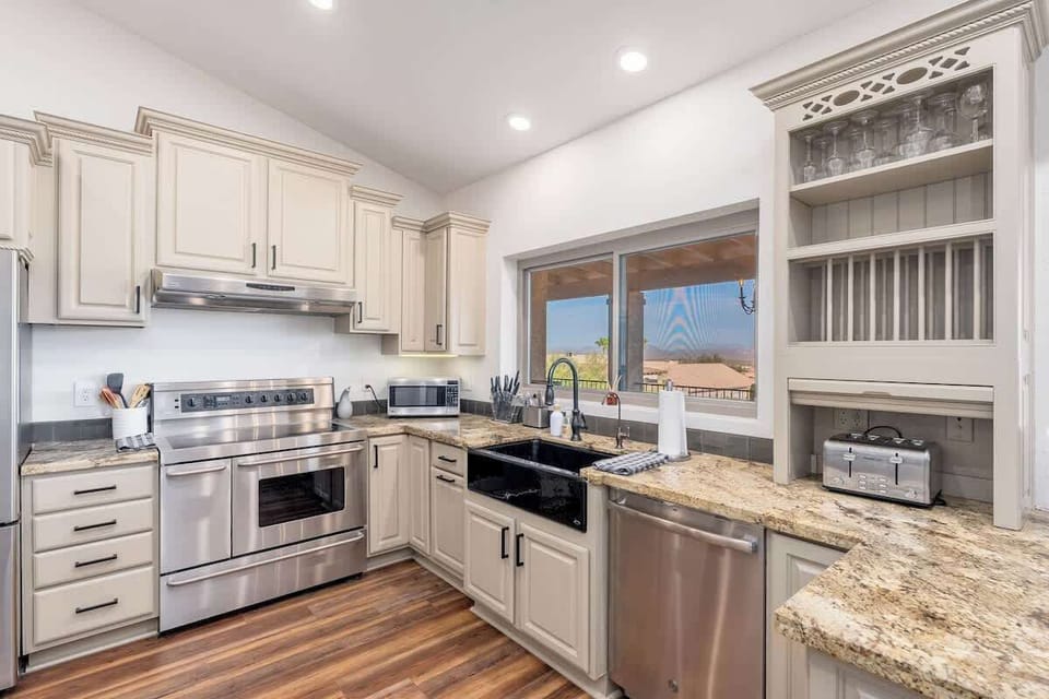 Your gourmet kitchen with granite counters and stainless appliances makes meal prep a pleasure, while mountain and valley views through the window inspire culinary creativity.