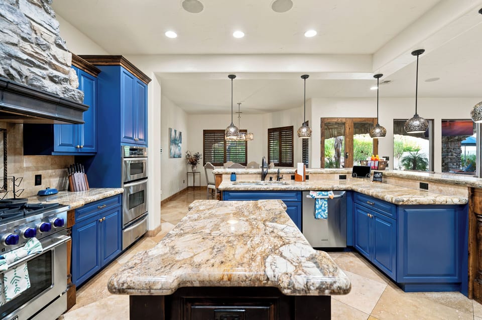 Stunning chef’s kitchen with bold blue cabinets and oversized granite island