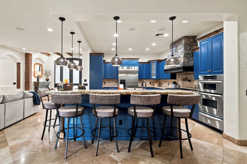 Stylish gourmet kitchen with blue cabinets and a large island for 6