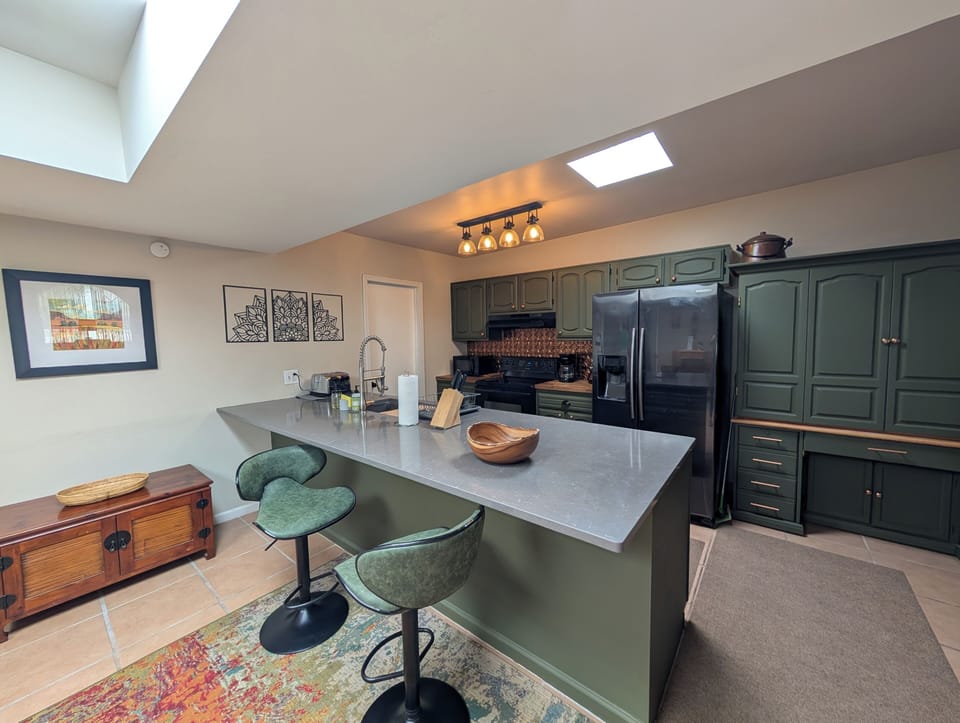 Fully equipped kitchen with breakfast bar. Large fridge, electric stove top, coffee maker, electric kettle & big stainless steel sink. 