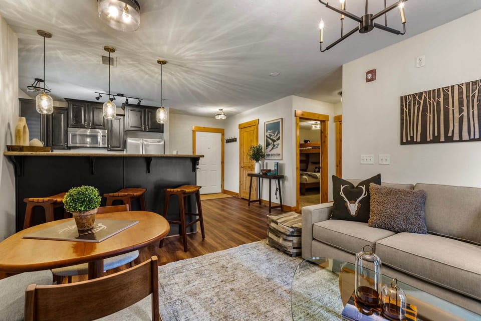 Step into your cozy mountain retreat, where warm wood accents and modern touches create the perfect home base for your getaway. Unwind on the plush sofa or gather around the inviting dining table after a day of adventure.