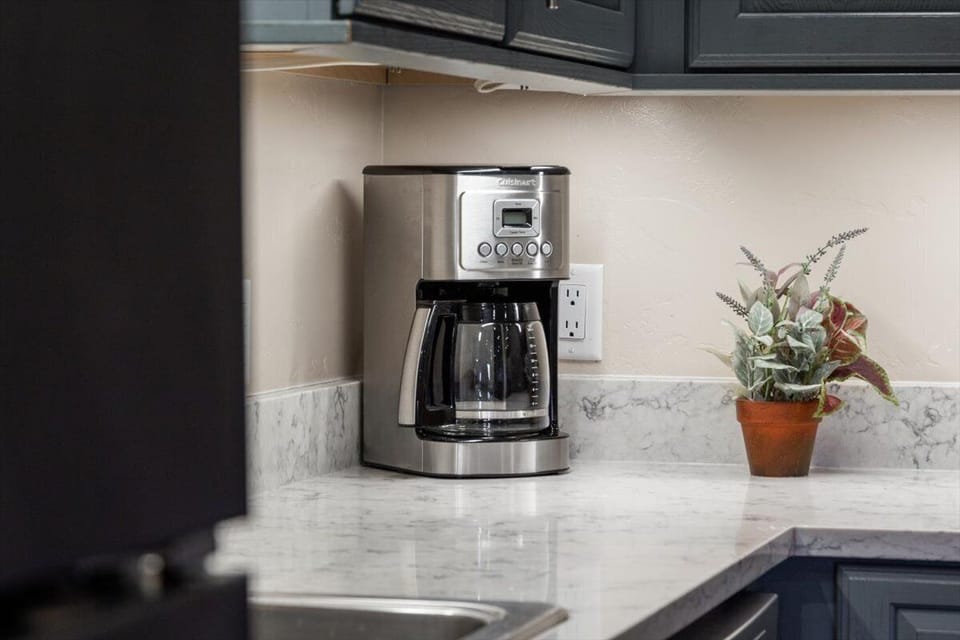 Modern kitchen with coffee maker and sleek marble-look counters