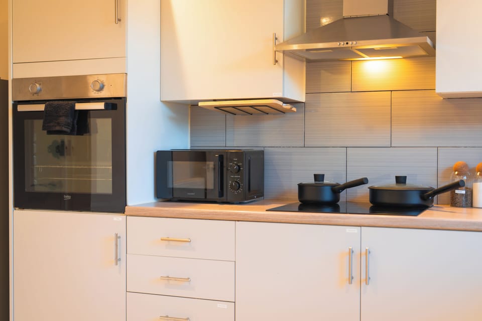 Modern, fully equipped kitchen with sleek finishes and warm lighting