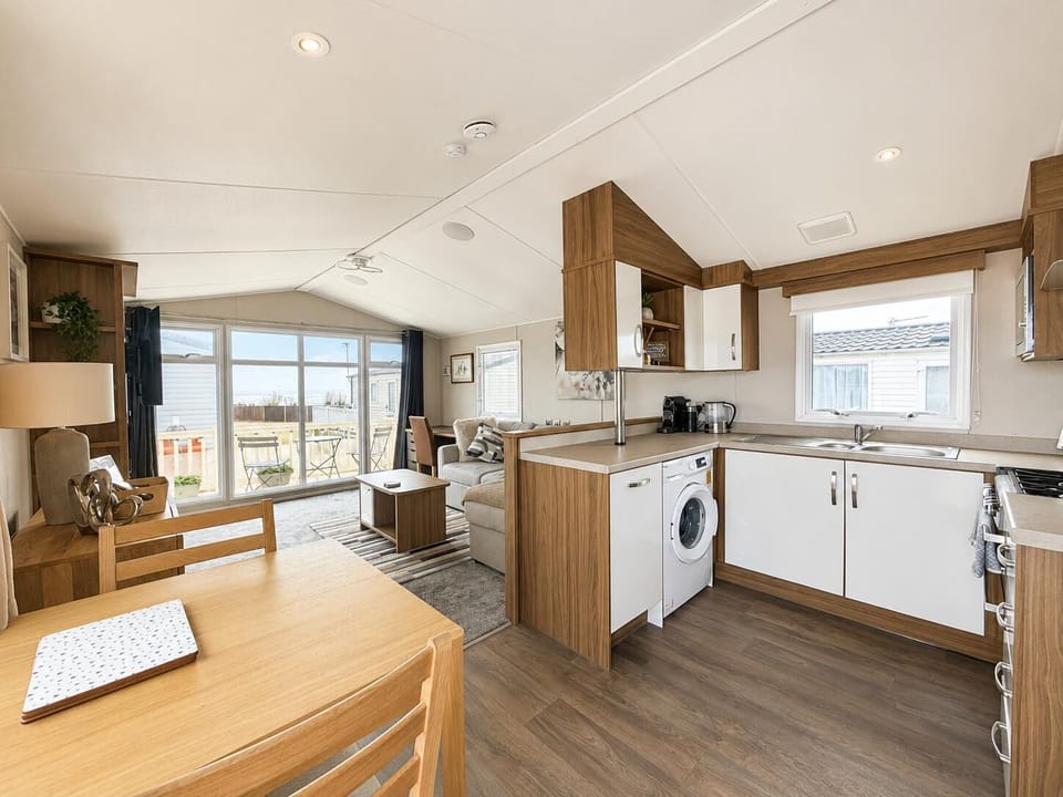 Bright, modern and made for easy stays, this open-plan caravan interior feels warm, airy and welcoming. With a cosy lounge, dining space for four and a smart compact kitchen