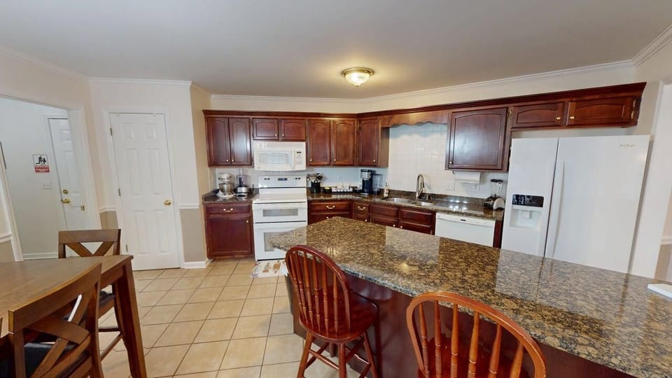 Kitchen with bar, double oven, dual coffee maker, mixer, & cookware for cooking