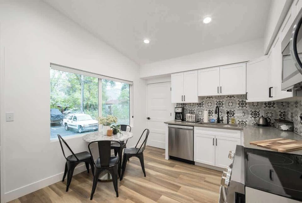 Fully-stocked, open kitchen with table and seating for four. 