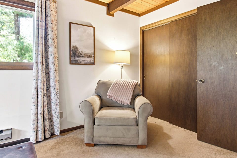 Settle into a quiet reading corner with soft lighting, cozy textures, and peaceful cabin warmth.