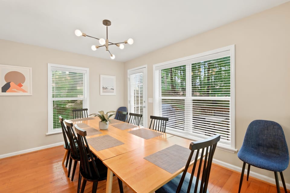 This bright dining room is framed by large windows overlooking leafy views, turning every meal into a front-row seat to the surrounding forest.