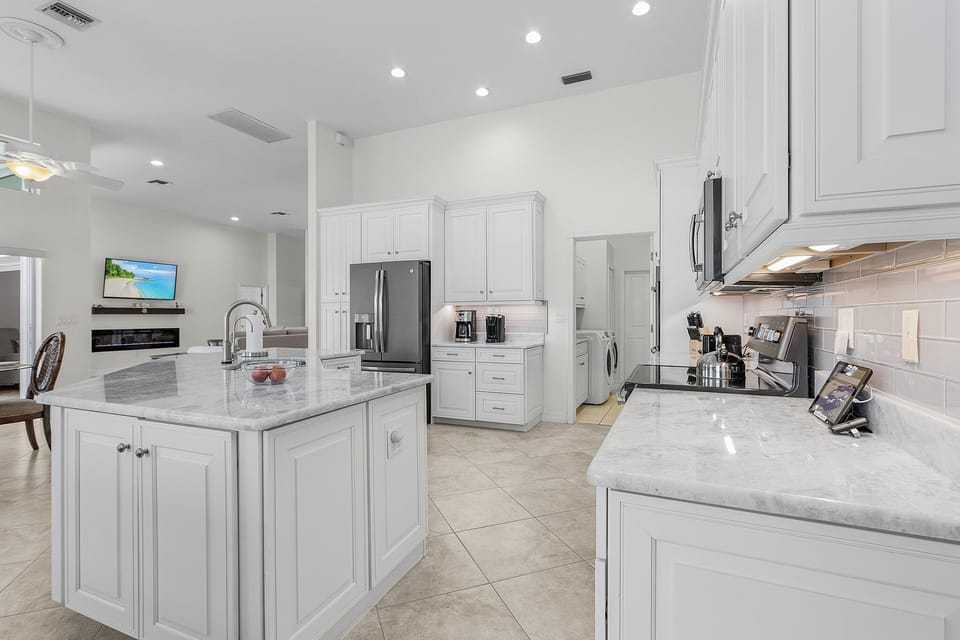 A true chef’s kitchen equipped with a massive custom island, granite countertops, a double oven, and matching GE appliances.