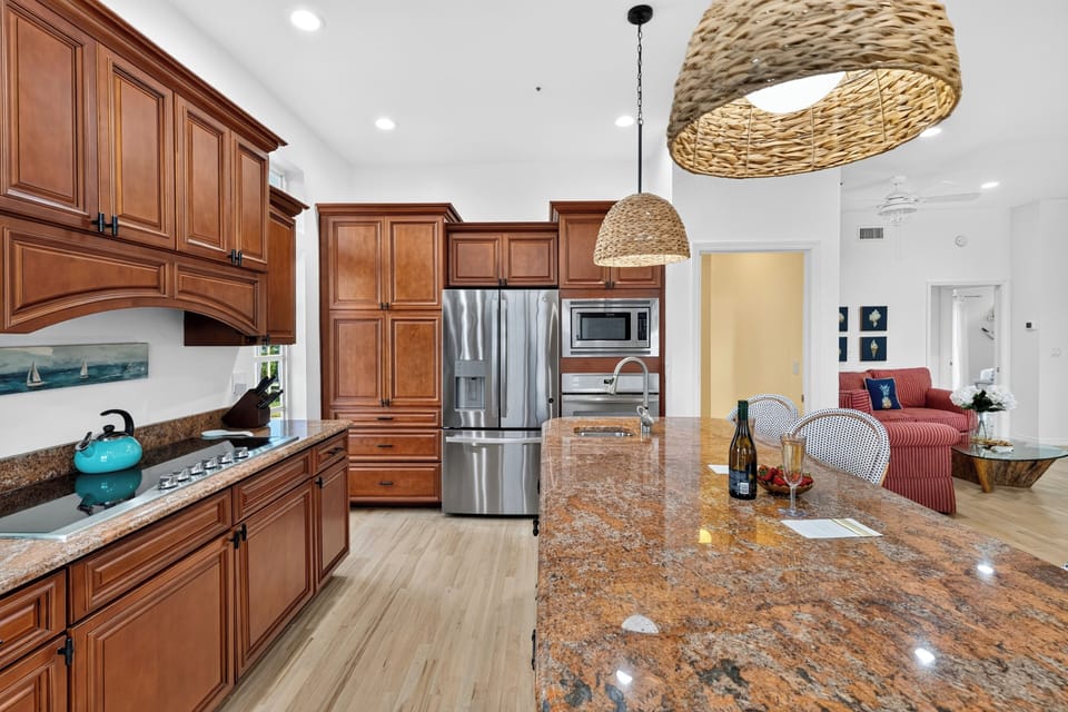 Warm wood cabinetry and high-end stainless steel appliances complete this spacious chef's kitchen.