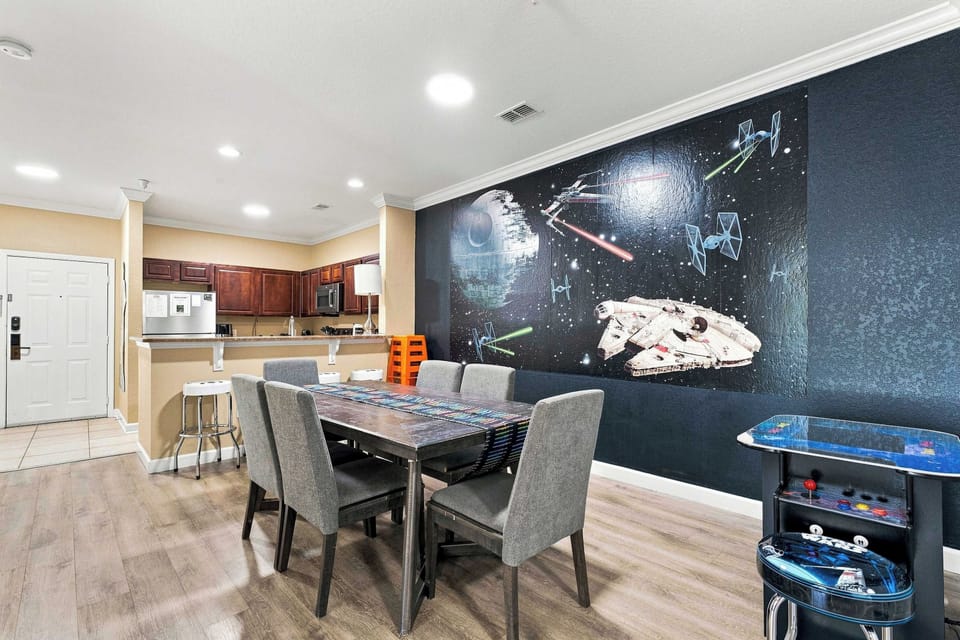 The adjacent dining area features a table for six, and a cafe-table-style home arcade video game featuring 516 classic video games, along with an assortment of family-friendly board games to keep the kids busy on relaxed vacation days.