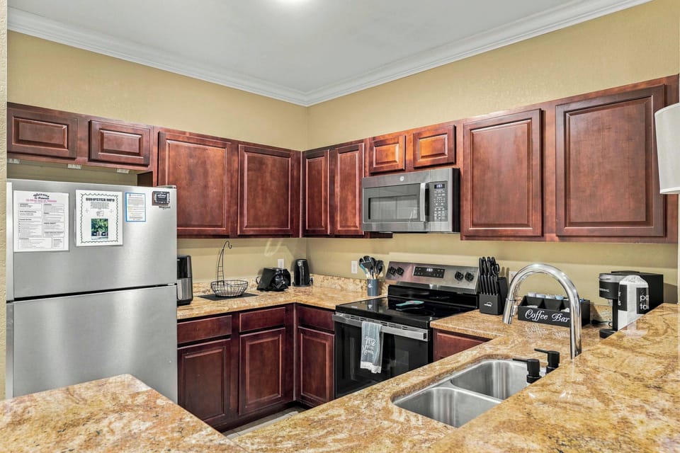 Step past the life-sized welcoming droids you’re looking for into the space cantina full kitchen, with warm red-and-brown stone countertops, stainless and black appliances, sci-fi-inspired small appliances, a complimentary coffee/tea bar, 