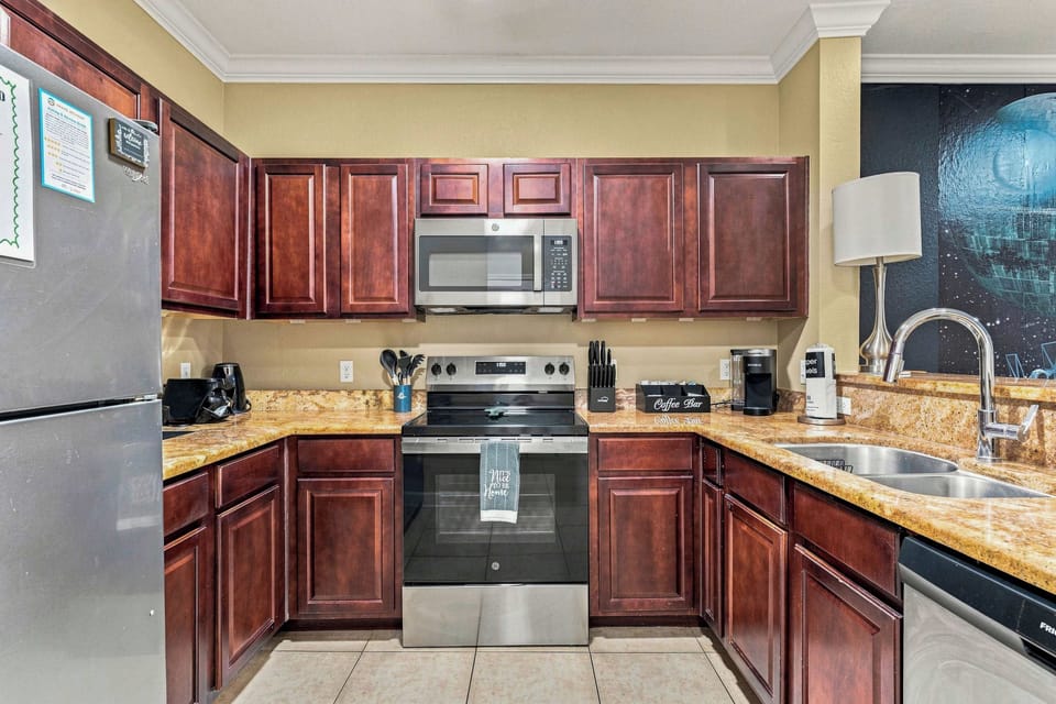 Step past the life-sized welcoming droids you’re looking for into the space cantina full kitchen, with warm red-and-brown stone countertops, stainless and black appliances, sci-fi-inspired small appliances, a complimentary coffee/tea bar, 