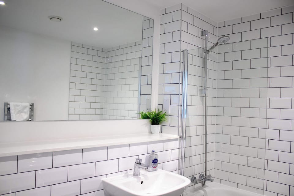 Refresh and unwind in the modern bathroom, complete with a bath and overhead shower. Contemporary finishes and fresh towels provide a comfortable and practical space for your daily routine.