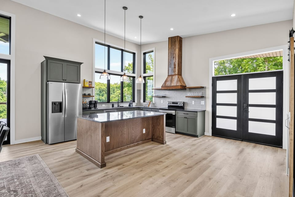 Bright modern kitchen with large island, tall windows, and designer finishes