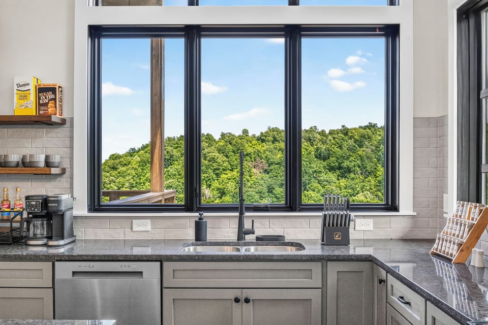 Bright modern kitchen with panoramic windows and serene forest views