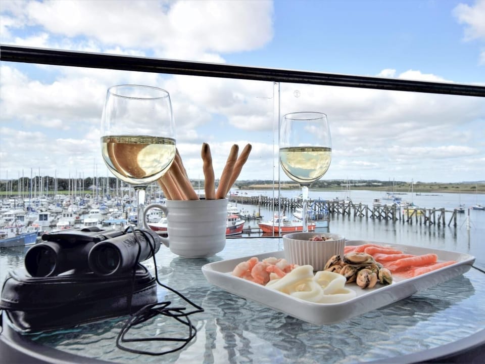 Boats come and go while you enjoy fresh seafood and glass of your favourite wine