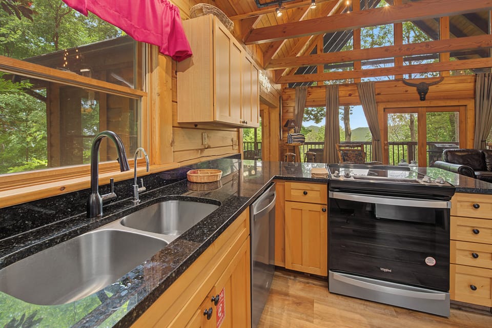Prepare meals in your fully equipped kitchen with gleaming granite counters, stainless steel appliances, and sweeping forest views through floor-to-ceiling windows that bring the outdoors in.