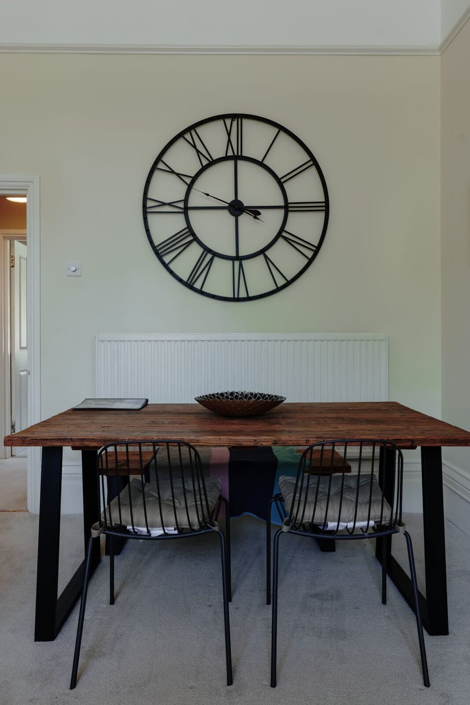 The bright living room offers a stylish dining table, smart TV, and cosy sofa for relaxing stays