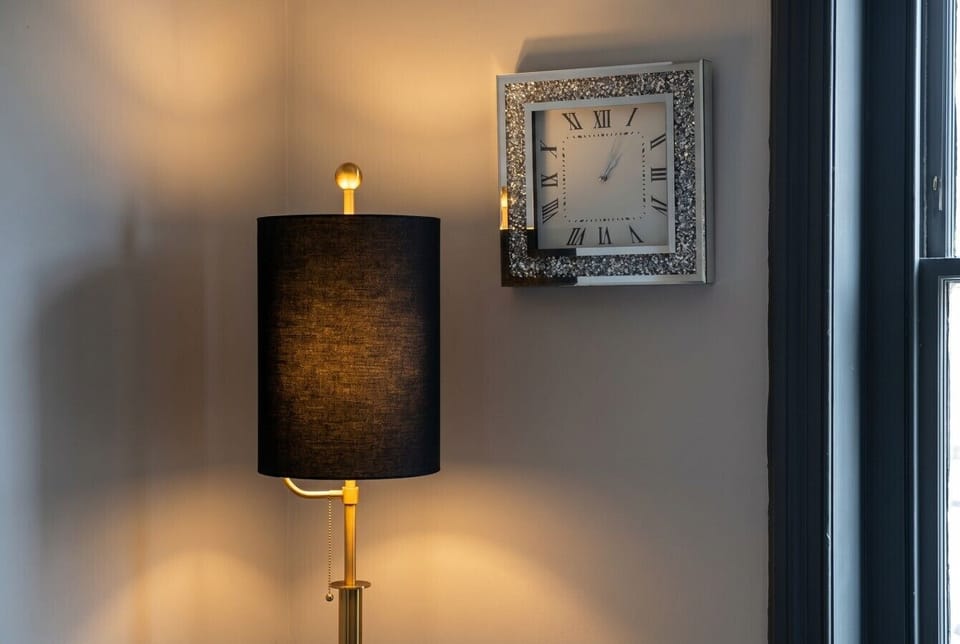 Warm lamplight and a statement clock add a homely finishing touch.