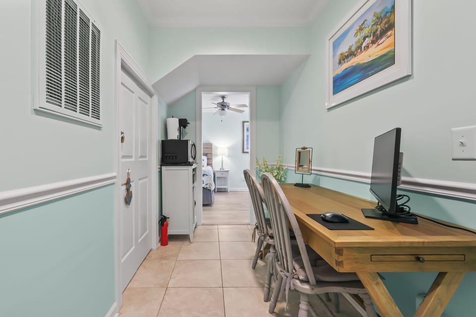 Your workspace awaits with coastal charm—settle in at this inviting desk, complete with modern tech, soft light, and beachy vibes just steps from your cozy retreat.