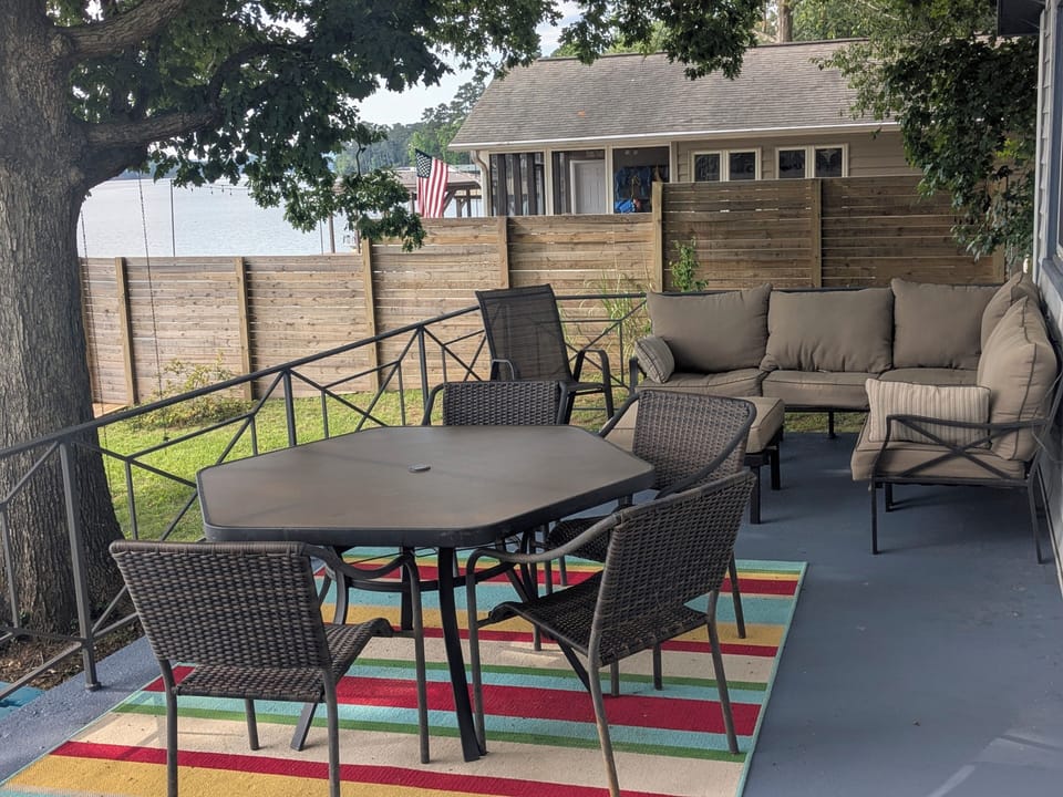 Private shaded patio with lounge seating, dining area, and water views
