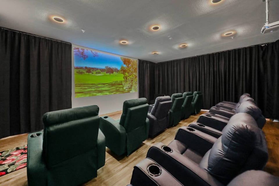 Private theater room with reclining seats and a big screen.