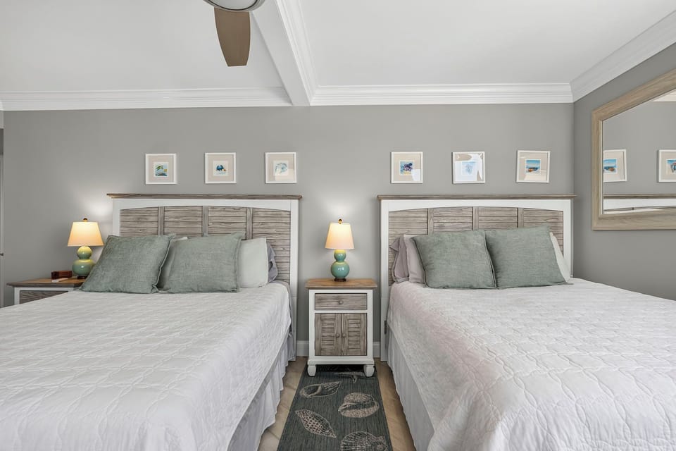 Guest bedroom with two full size beds and balcony access