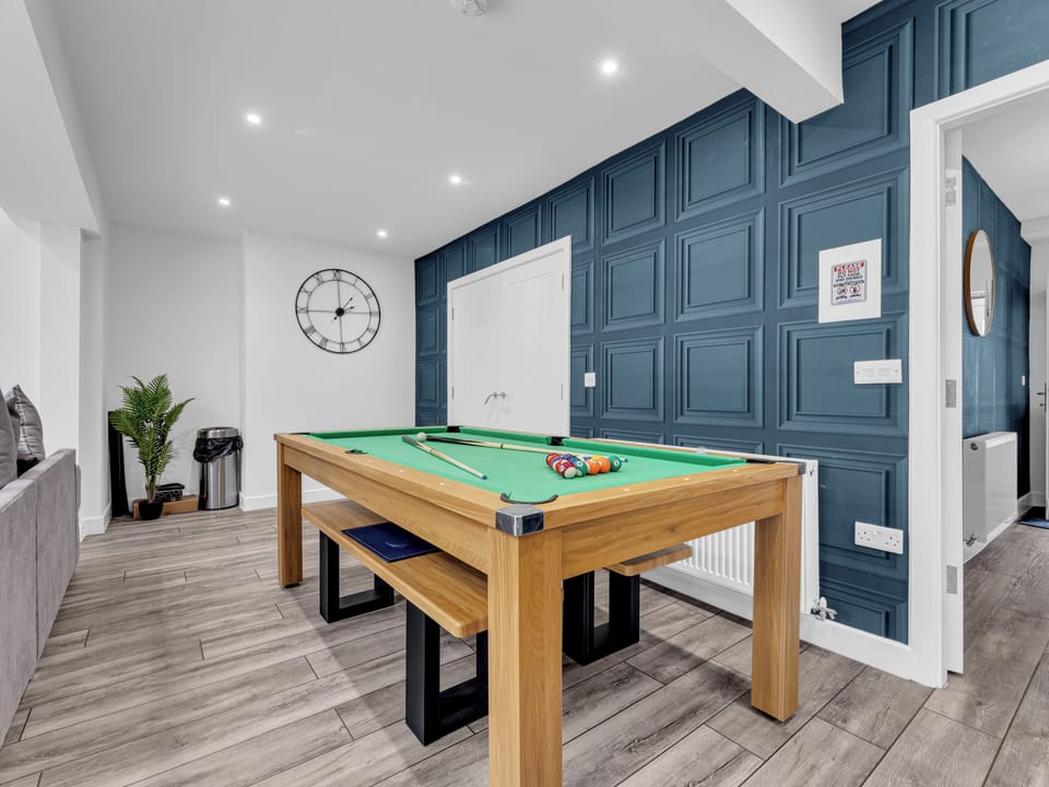 Modern games room with stylish pool table and striking blue feature wall