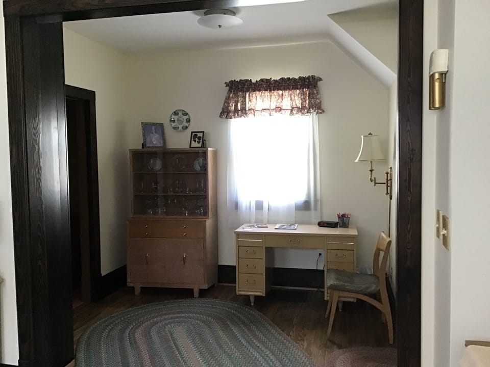 Office area with desk & hutch. Wine glasses on top, board games on the bottom.
