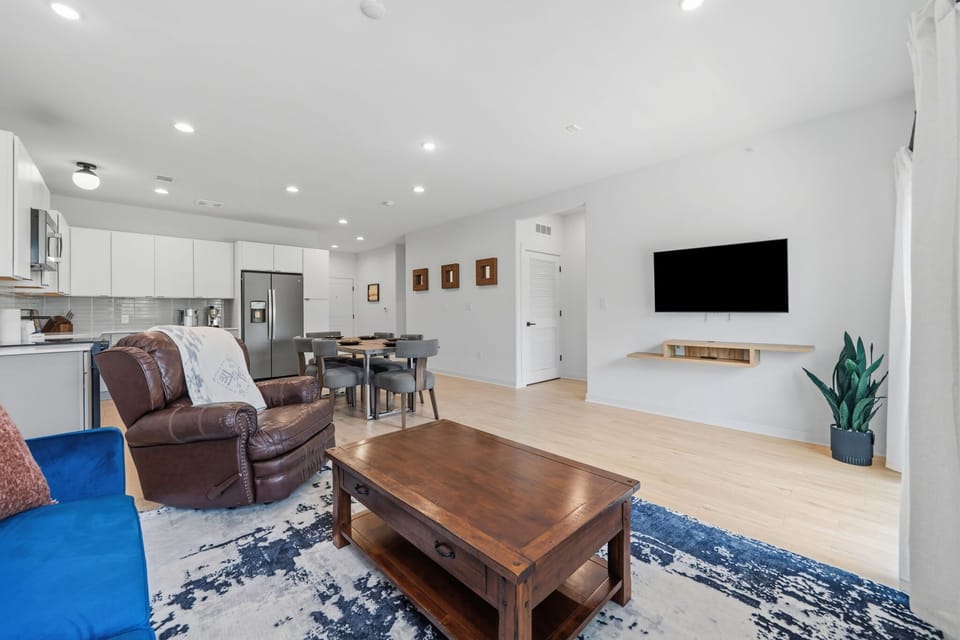 Living room w/ smart TV, full-size futon, & balcony access