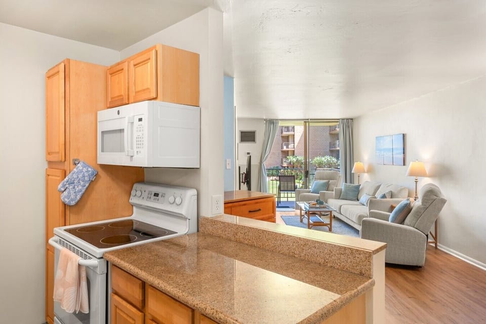 Bright open-concept living space with a full kitchen and private lanai access.
