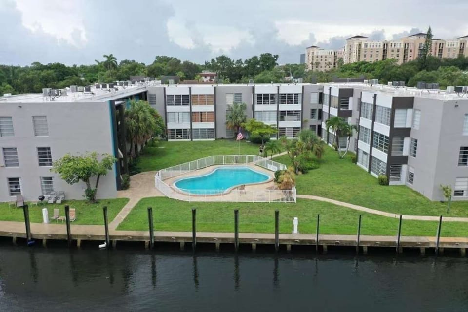 Aerial view of pool courtyard beside the water and grassy grounds