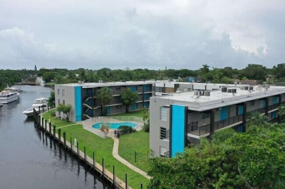 Aerial view of waterfront buildings, pool, and nearby boats