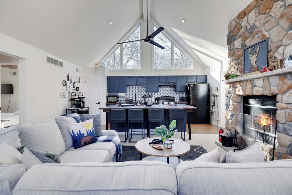 Bright, open living space with soaring ceilings and a cozy fireplace.