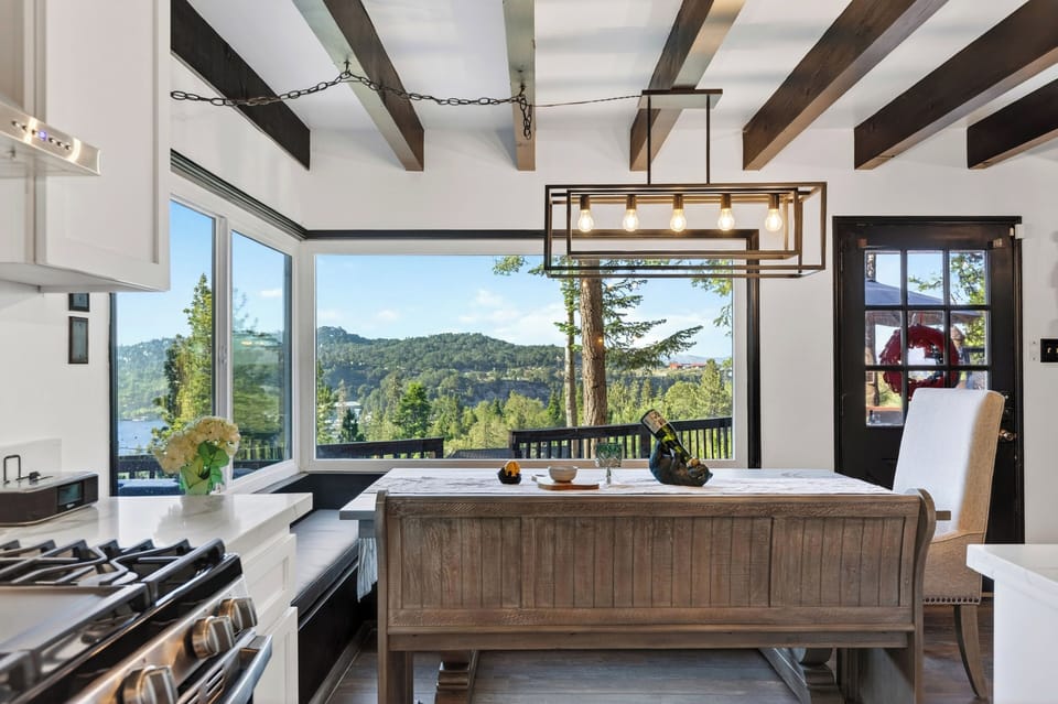 Dining with peaceful lake views framed by treetops and oversized windows.