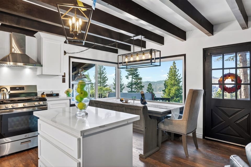Bright kitchen and dining area with lake views framed by oversized windows.