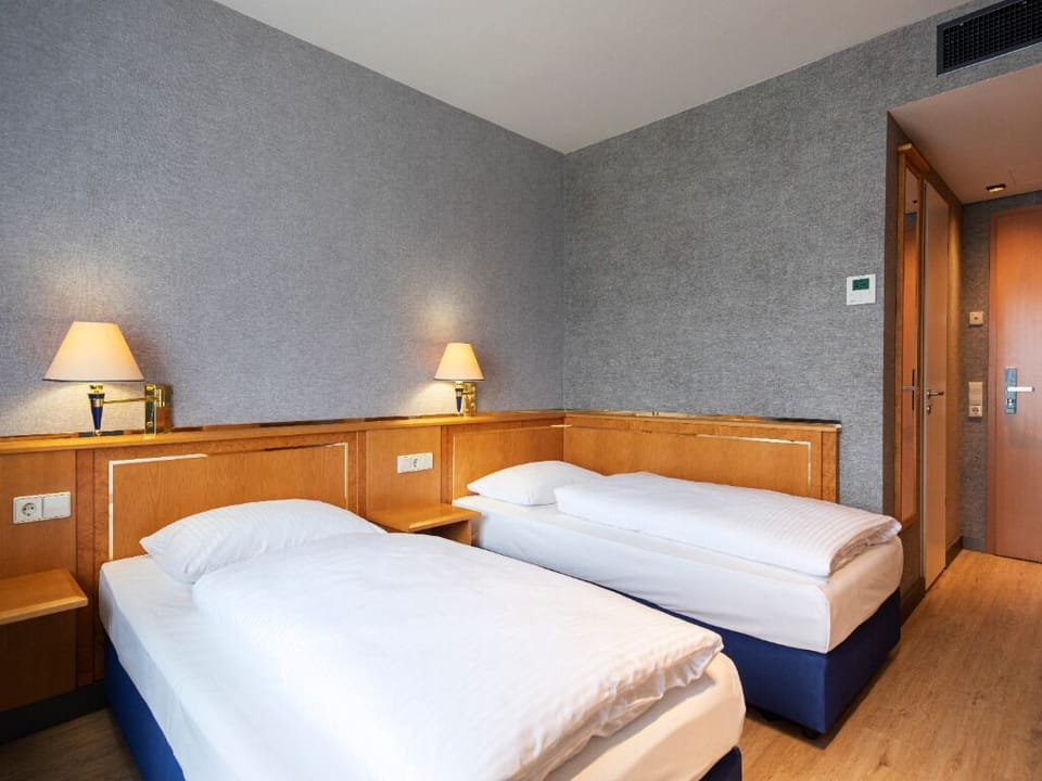 Wake refreshed in a tidy twin room with soft lighting