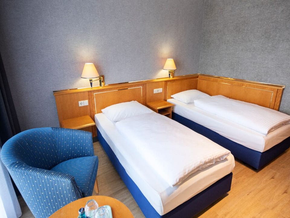 Stretch out on crisp twin beds beside a cozy chair