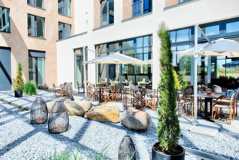 Sip morning coffee under umbrellas in a tranquil courtyard.
