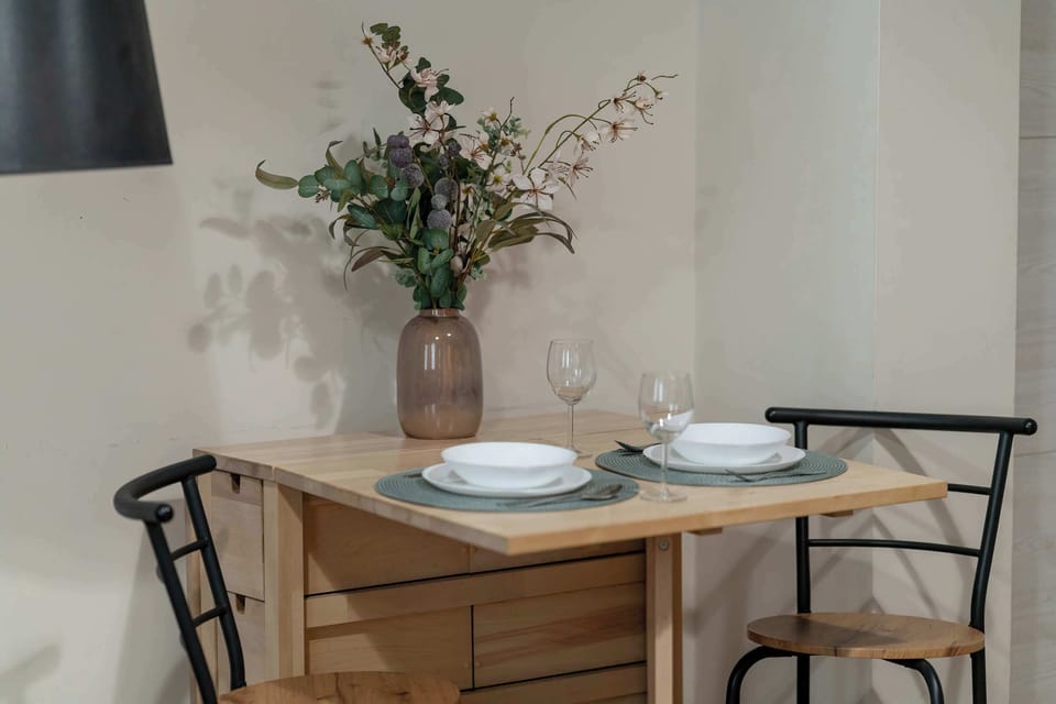 Dining table prepared for guests with elegant tableware and fresh flowers.
