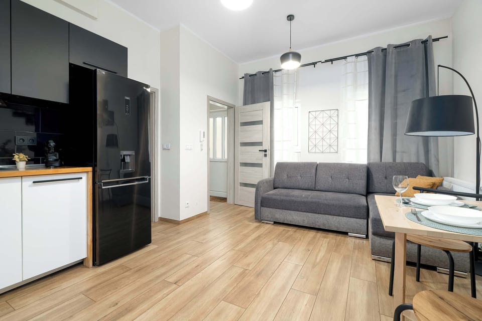 Wide view of the studio showcasing the lounge, dining space and modern kitchenette.