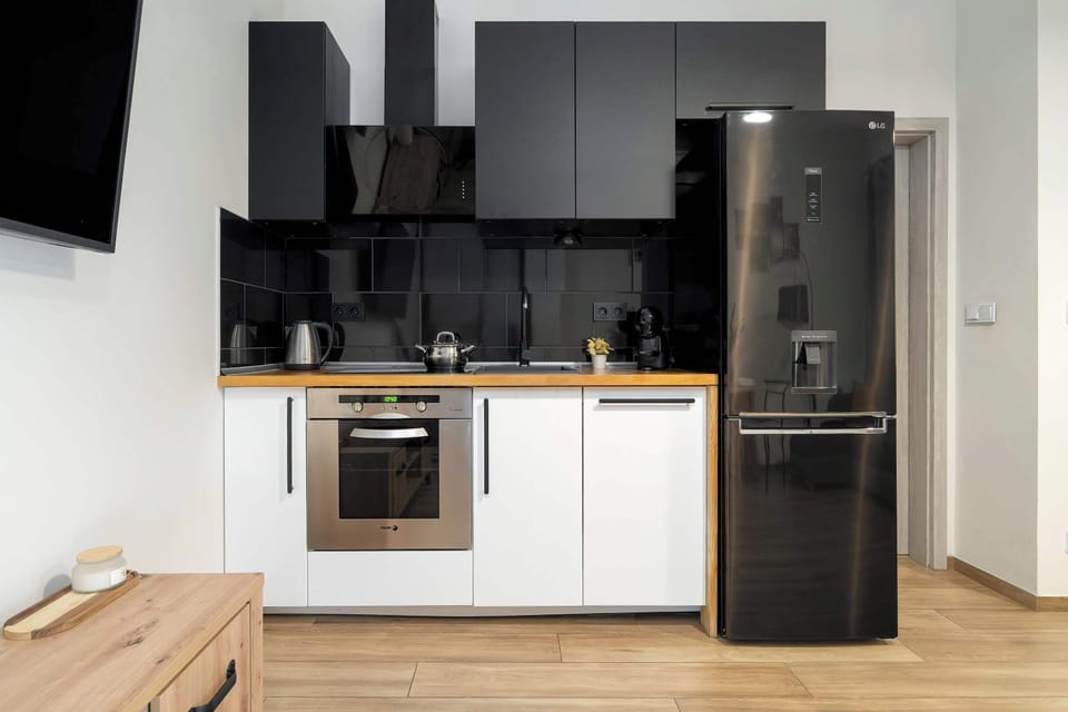 Contemporary kitchen with sleek black finishes, quality appliances and practical workspace.