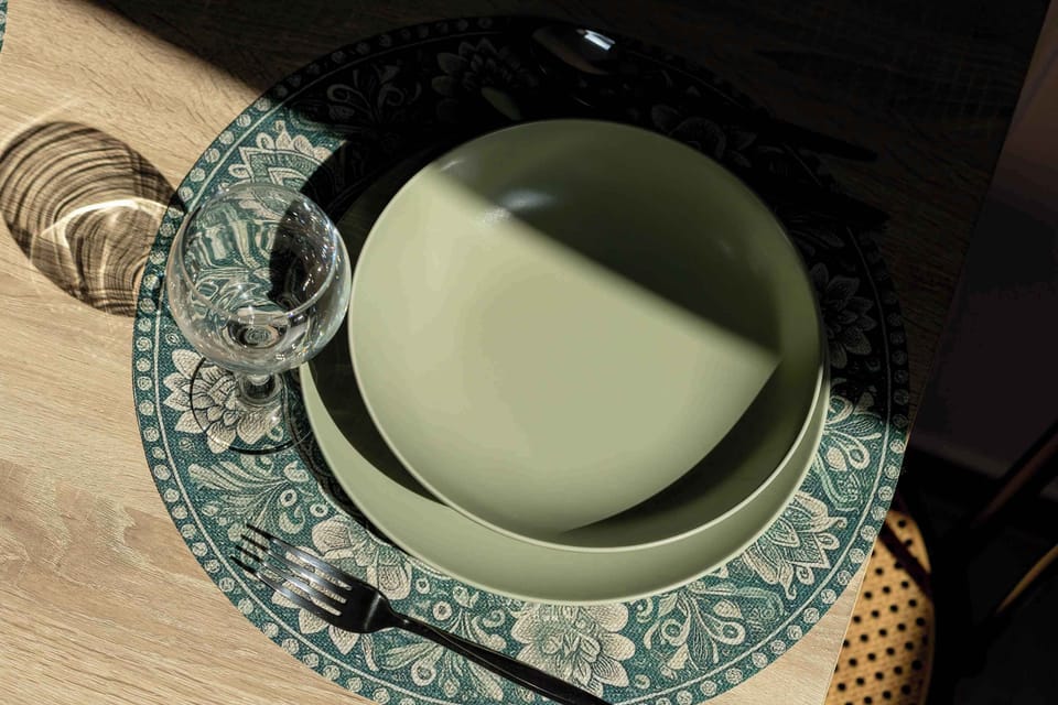 Elegant table setting prepared for guests with modern dinnerware and decorative accents.
