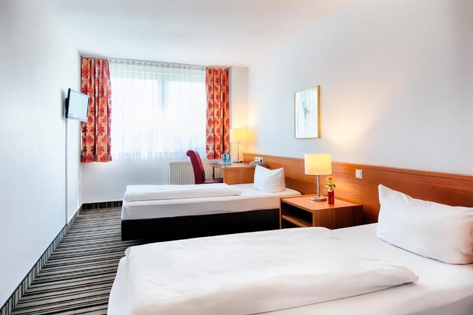 Rest easy in a classic, airy room with soft lamplight.